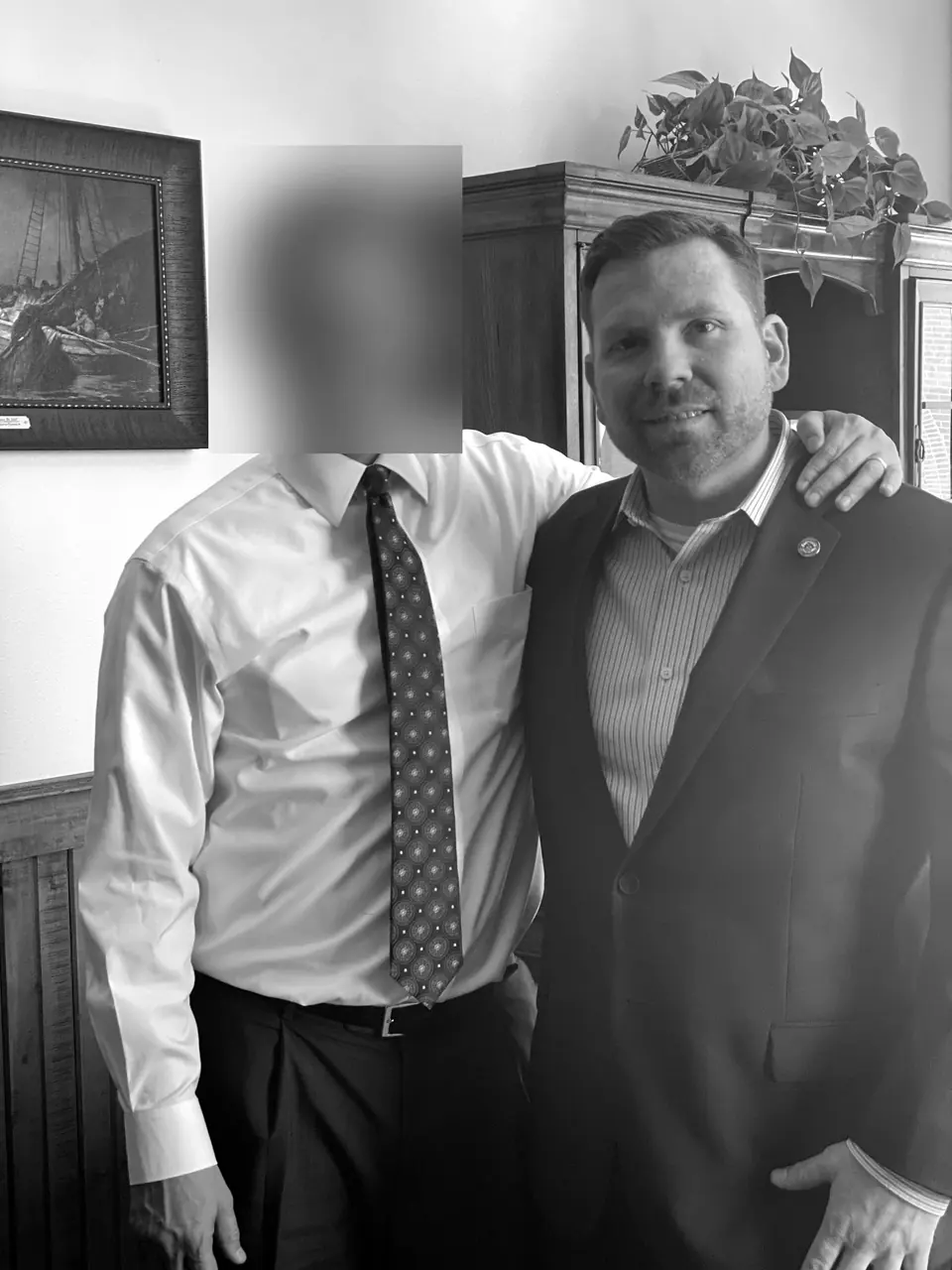 Craig Smith in a suit with a colleague in an office; colleague’s face obscured