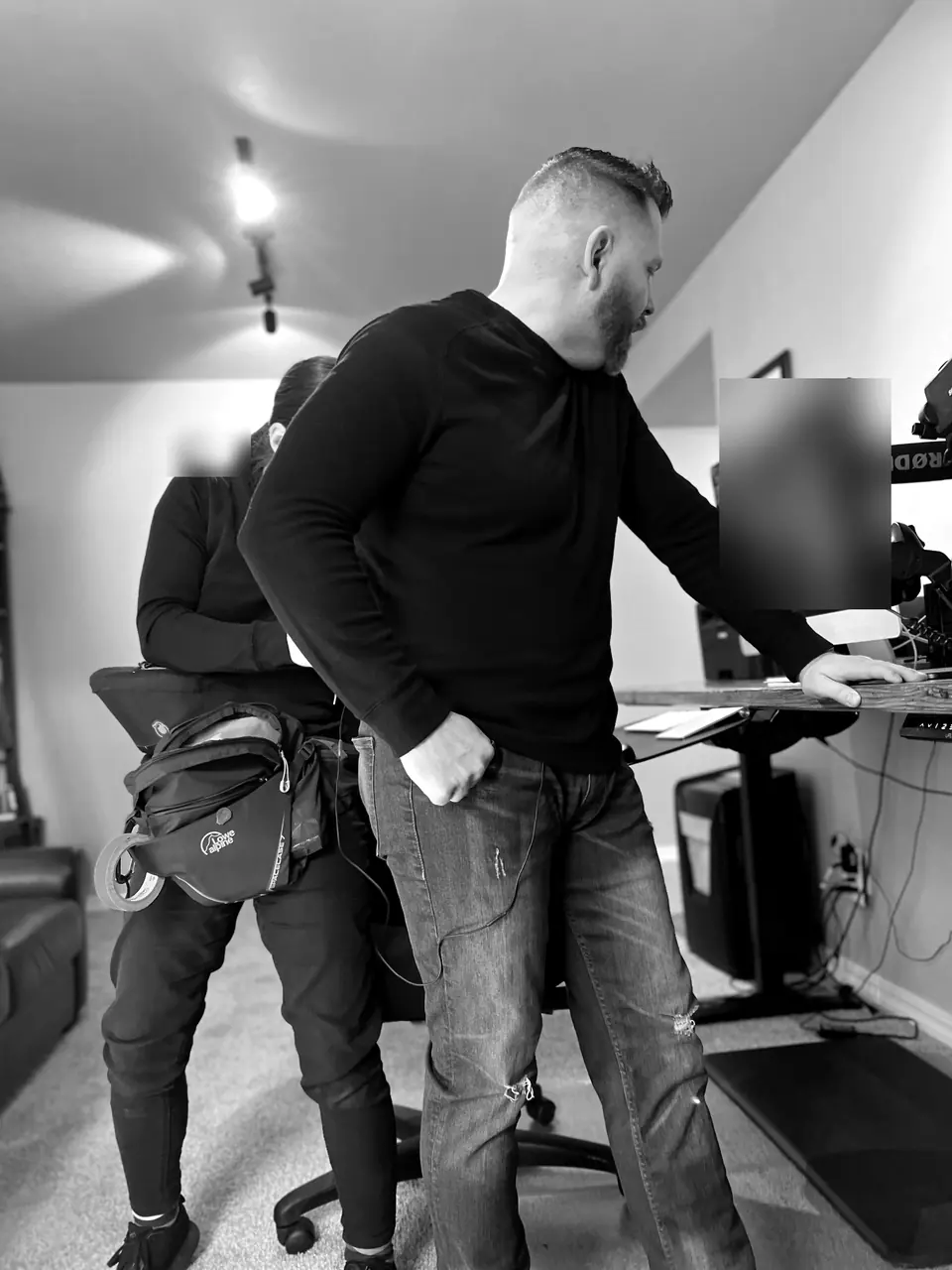 Behind the scenes filming for A&E’s Accused: Guilty or Innocent? (John Lott case): Craig Smith leaning on his desk with the camerawoman behind him; monitor obscured