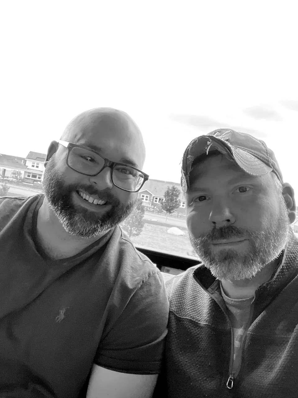 Craig Smith with John Lott: selfie outside, Craig in a cap